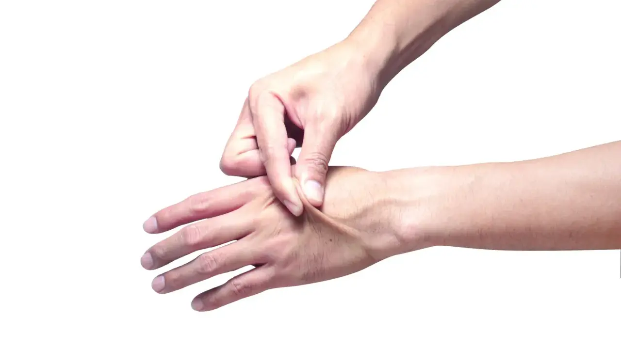 Mano che pizzica la pelle per testarne l'elasticità.