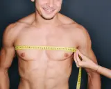 Uomo sorridente con metro da sarto intorno al petto, un passo per eliminare grasso petto uomo.