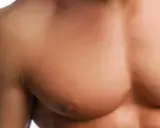 Primo piano del torace di un uomo con muscoli pettorali definiti, che potrebbero essere il risultato di allenamento o protesi pettorali uomo.