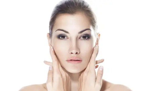 Viso di donna con mani che accarezzano le guance. Ci si chiede: dermamelan dopo quanto fa effetto per una pelle perfetta?