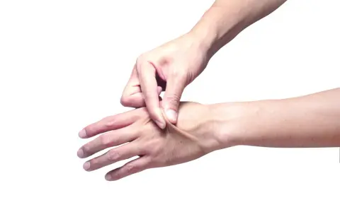 Mano che pizzica la pelle per testarne l'elasticità.