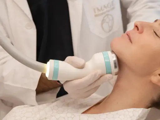 Medico esegue trattamento onda coolwaves sul collo di una donna per migliorare l'aspetto della pelle.