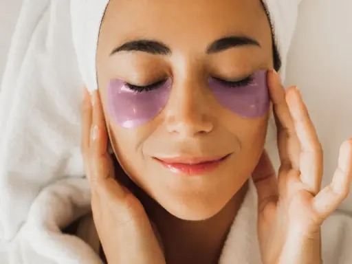 Donna con impacchi viola sotto gli occhi, un rituale di bellezza con punture di vitamine per occhiaie.