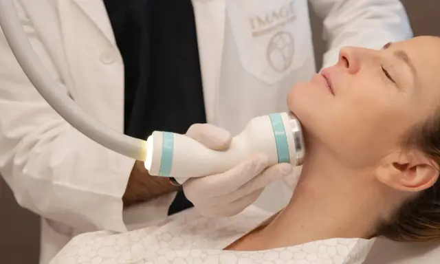 Medico esegue trattamento onda coolwaves sul collo di una donna per migliorare l'aspetto della pelle.