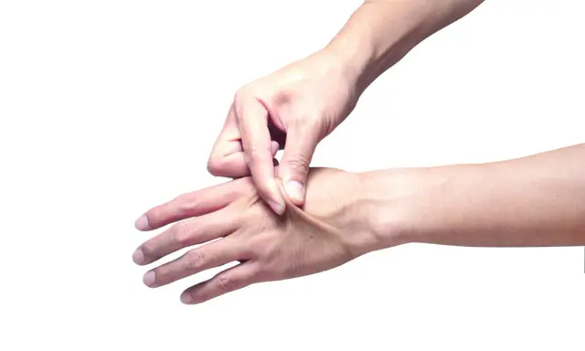 Mano che pizzica la pelle per testarne l'elasticità.