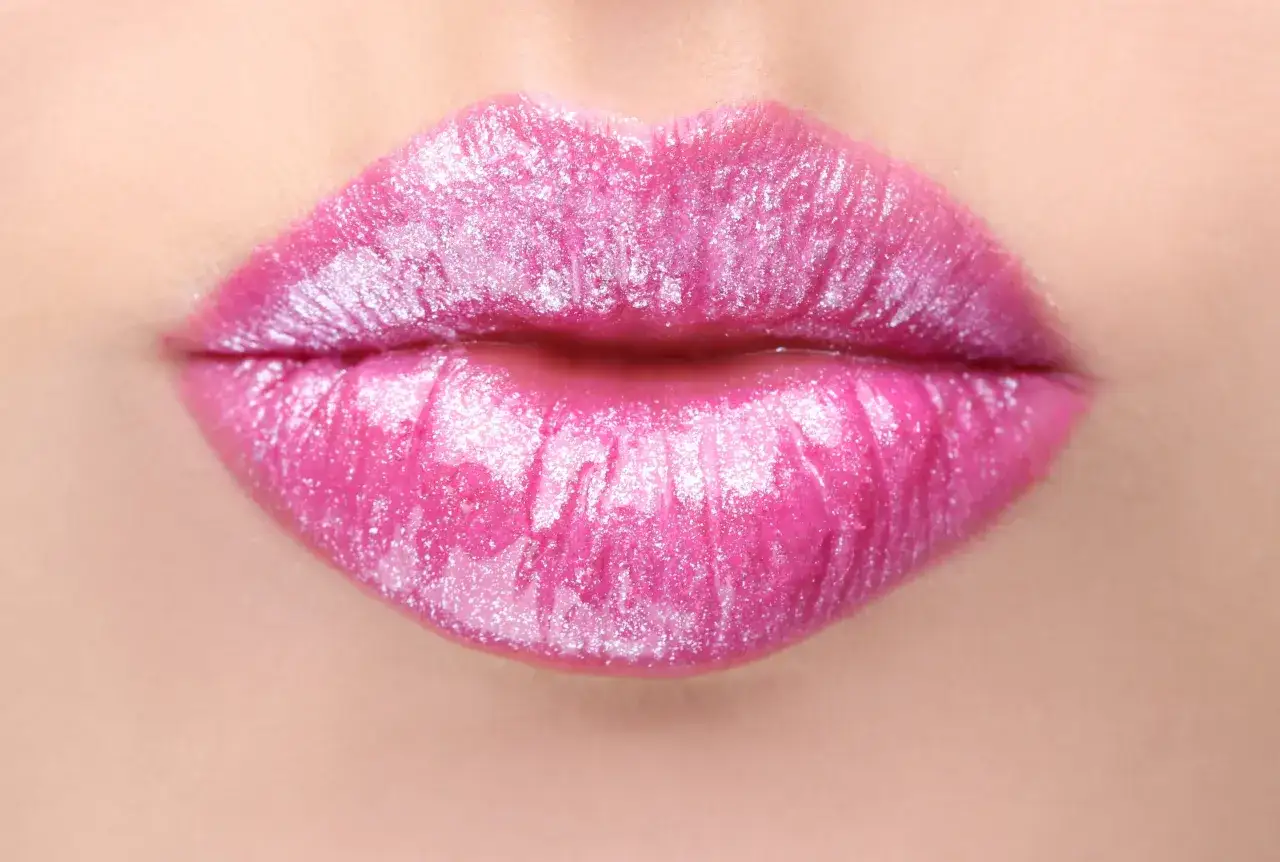 Labbra piene e luminose, effetto filler labbra a cuore, con un brillante fucsia scintillante.