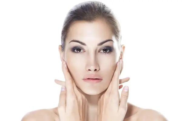 Viso di donna con mani che accarezzano le guance. Ci si chiede: dermamelan dopo quanto fa effetto per una pelle perfetta?