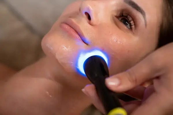 Primo piano di un viso sottoposto a biorivitalizzazione con luce blu. Informarsi sulle biorivitalizzazione viso controindicazioni prima del trattamento.