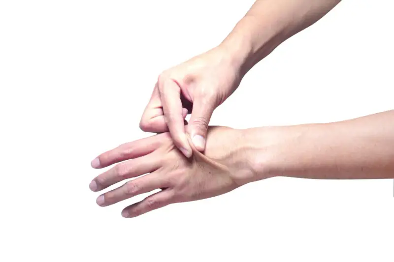 Mano che pizzica la pelle per testarne l'elasticità.